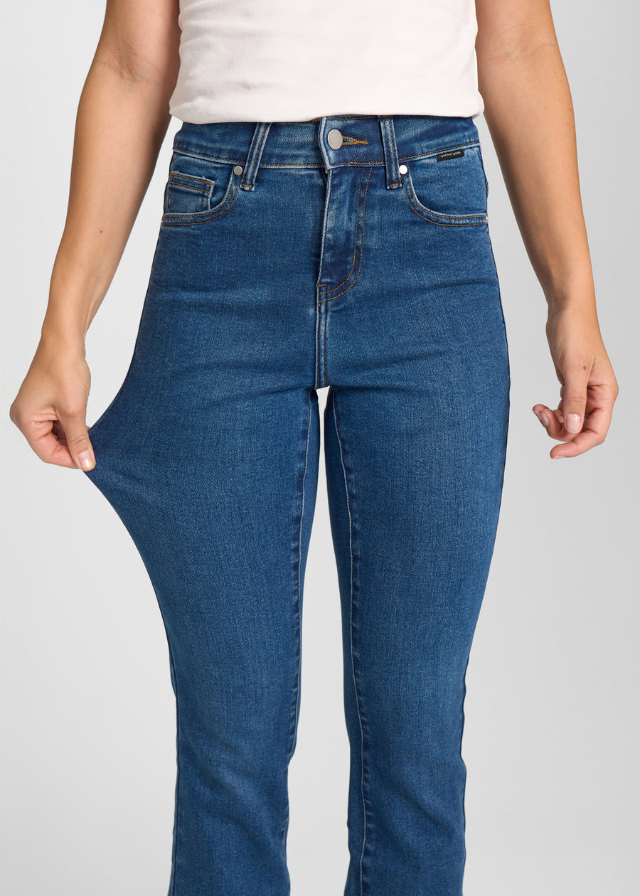 Model strækker jeansene ved låret for at vise stretch.