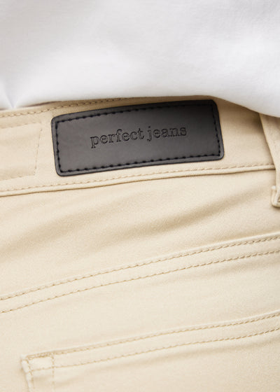 Baglommen på et par beige loose jeans, hvor man kan se logoet.
