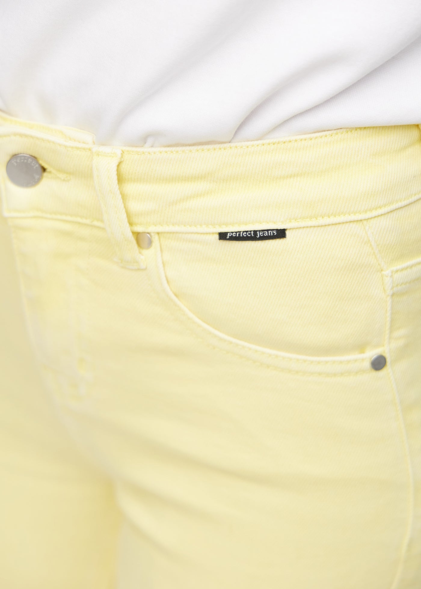 Forlommen på de lysegule slim capris i farven Lemonades – med tydeligt logo og syninger i fokus.