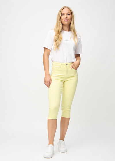Plus-size model går ind i billedet, strækker i sine capris, viser dem frem ved at dreje rundt, og forlader derefter billedet.
