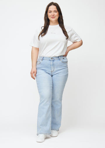 Plus-size model går ind i billedet, strækker i jeansene, viser dem frem ved at dreje rundt og forlader derefter billedet.