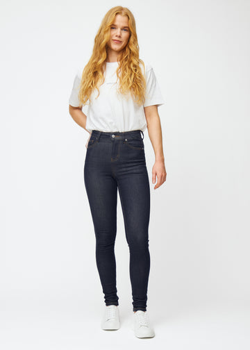 Model viser dyb mørkeblå denim jeans til kvinder i farven Midnights med skinny pasform i bevægelse.