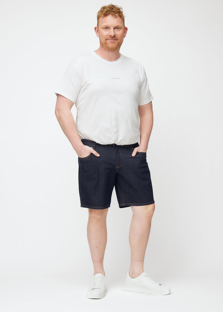 Plus-size model viser dyb mørkeblå denim shorts til mænd i farven Midnights med regular pasform i bevægelse.