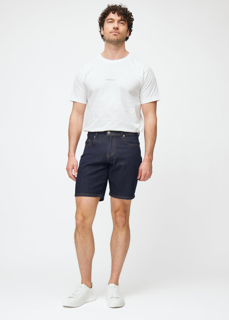 Model viser dyb mørkeblå denim shorts til mænd i farven Midnights med regular pasform i bevægelse.