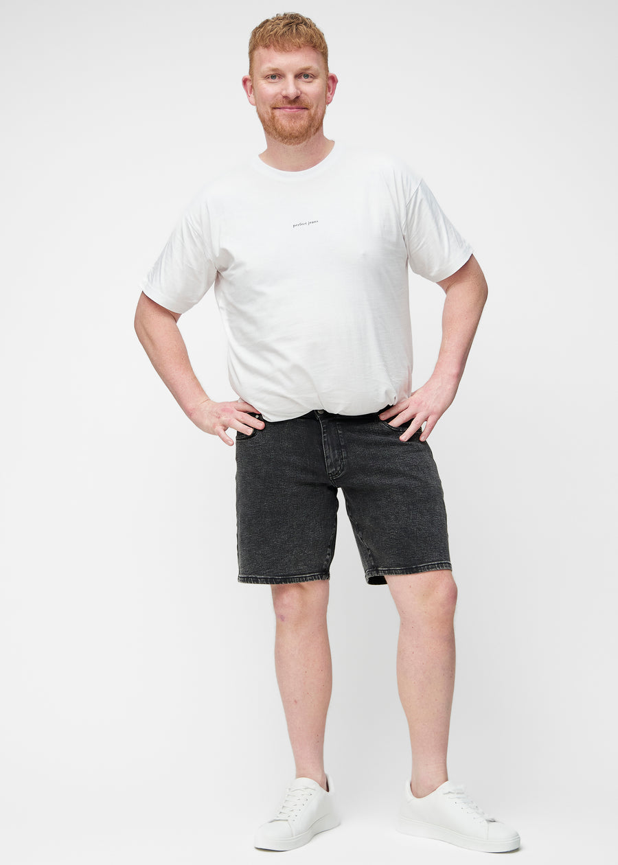 Plus-size model viser mørkegrå denim shorts til mænd i farven Shadows med regular pasform i bevægelse.