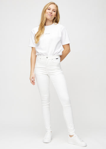 Model går ind i billedet, strækker i jeansene, viser dem frem ved at dreje rundt, og forlader derefter billedet.